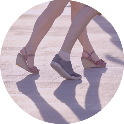 Männer- und Frauenbeine in Bewegung auf Asphalt.